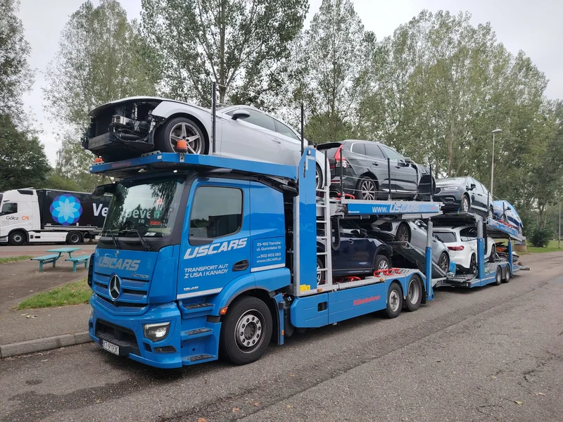 Niebieski autotransporter USCARS załadowany samochodami