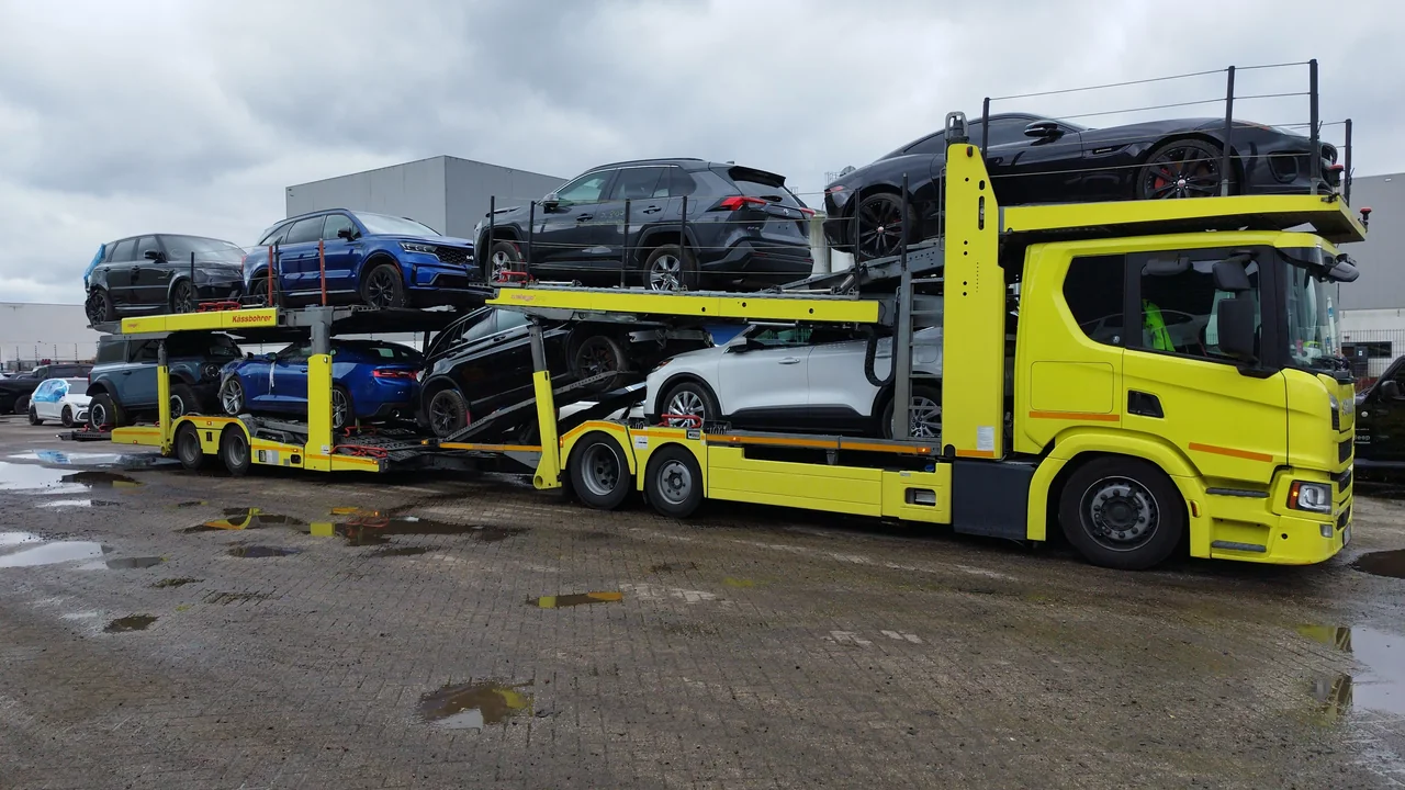 Załadowany autotransporter z samochodami na placu manewrowym